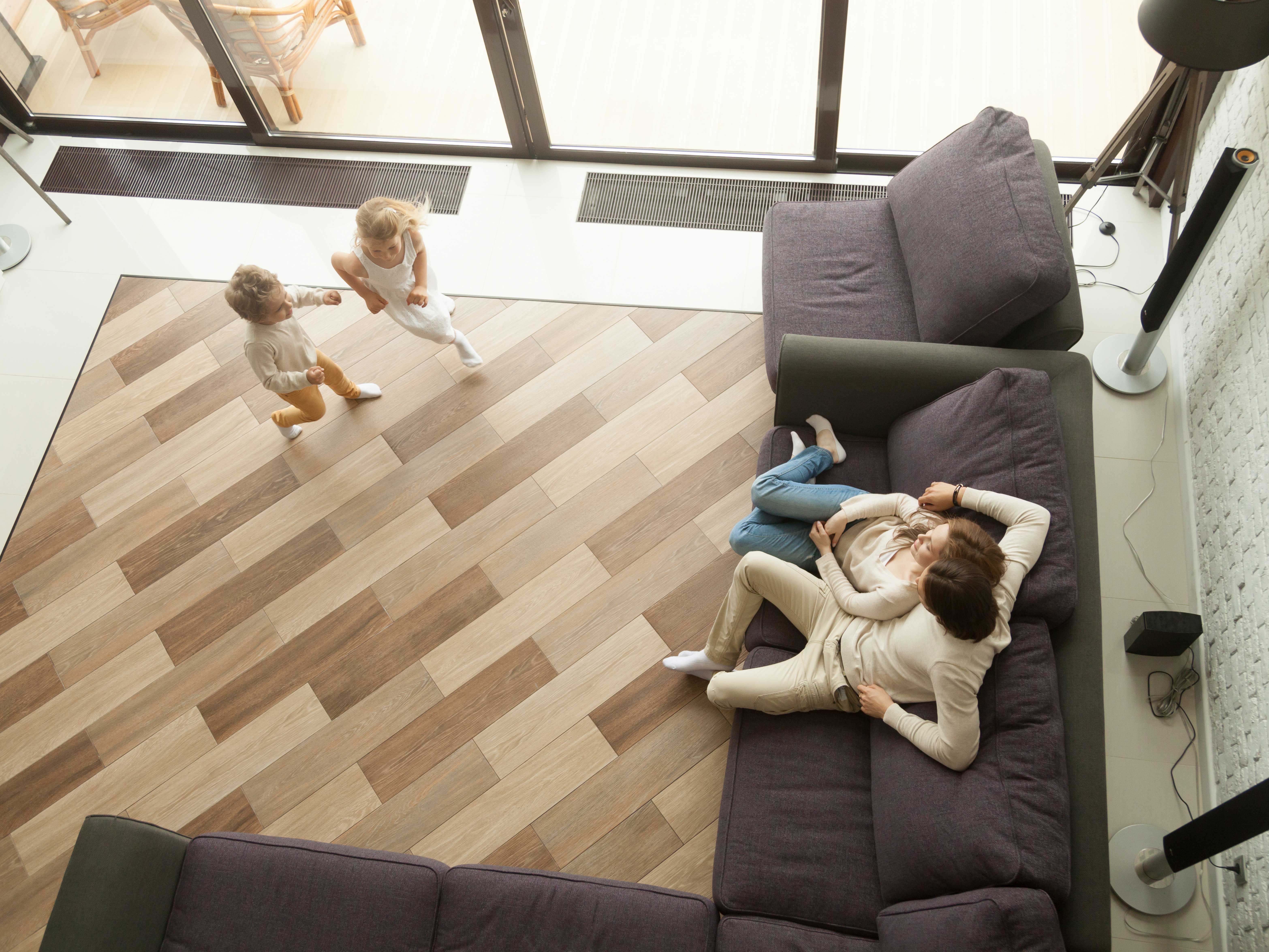 A woman comfortably lies in wooden floor room